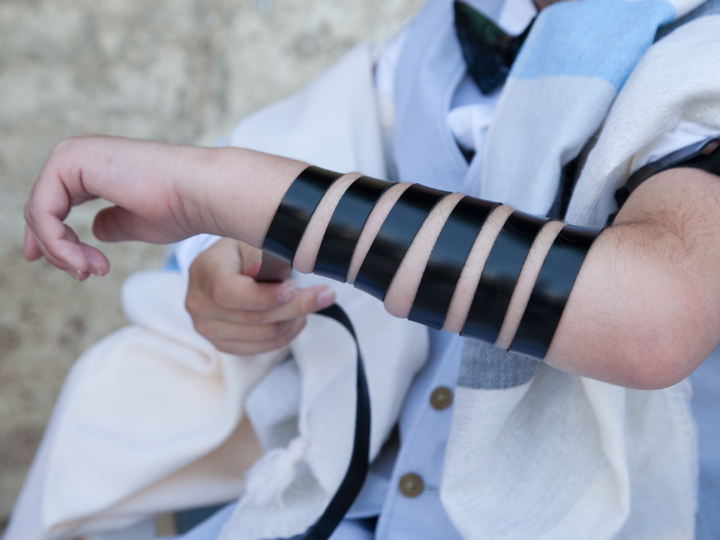 The arm of a man wrapped in a Tefillin.